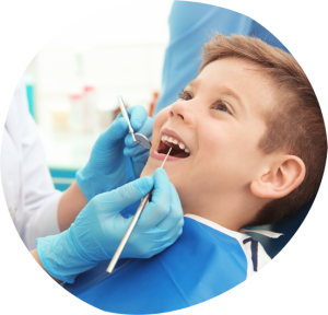 Child in dental chair receiving preventive care from pediatric dentist, smiling during examination with dental tools, emphasizing child-friendly dental services at Dental Care Group Kids in Aventura.