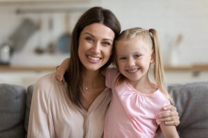 young girl and her mother smiling