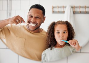 father and daughter brushing together