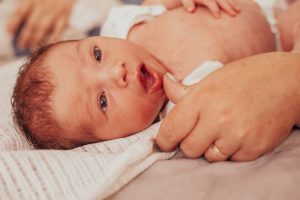 examining newborn baby for first tooth