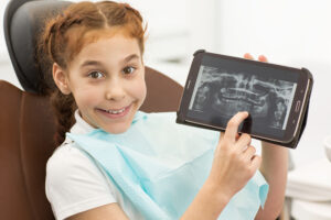 young girl pointing at dental x-ray