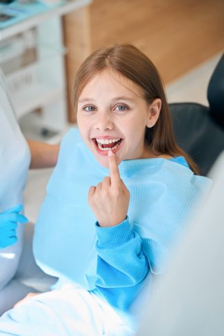 child shows off teeth at dentist